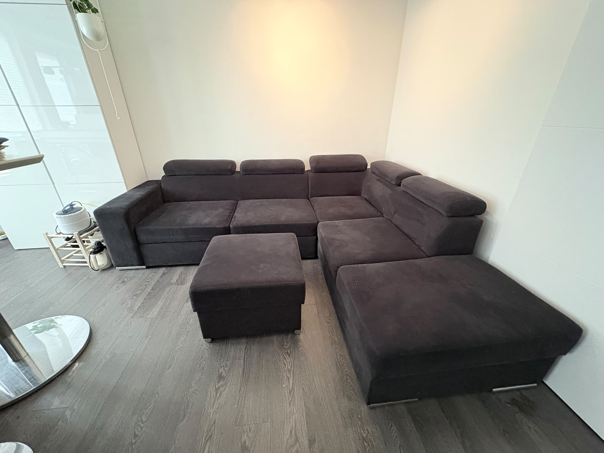 Large dark corner sofa and ottoman before collection in Leiden